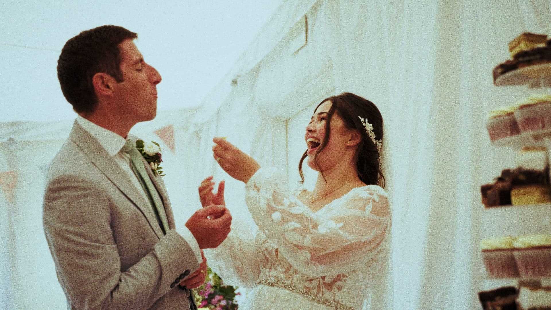 A couple laughing together inside a marquee, in a still from a 21frames wedding film