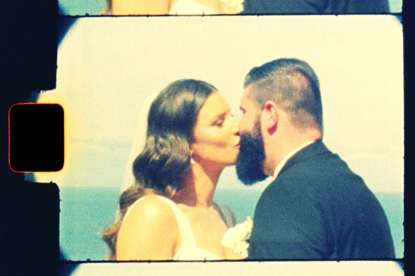 A Super 8 frame, sprocket hole and all, of the couple's first kiss by the sea
